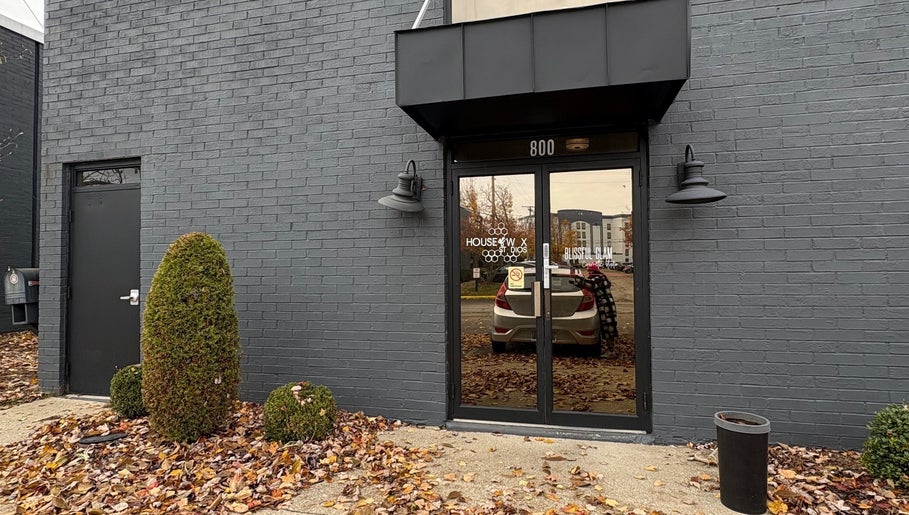 Entrance of Artistry Nail Lounge in Louisville, Kentucky, US with sleek gray brick exterior.