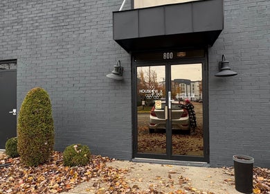 Entrance of Artistry Nail Lounge in Louisville, Kentucky, US with sleek gray brick exterior.