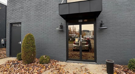 Entrance of Artistry Nail Lounge in Louisville, Kentucky, US with sleek gray brick exterior.