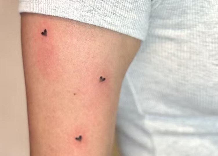 Arm with small heart tattoos from TEEMOOINK TATTOO, Surry Hills, New South Wales, AU showcasing minimalist design.