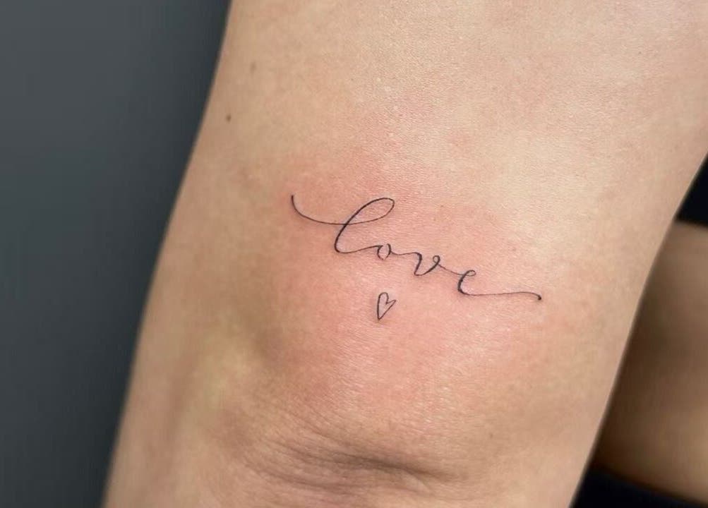 Minimalistic 'love' tattoo in script font at TEEMOOINK TATTOO, Surry Hills, New South Wales, AU.