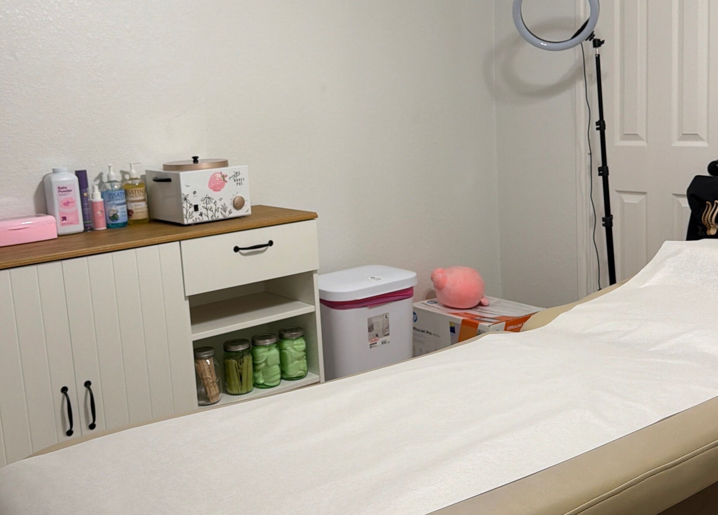 Cozy waxing room at Berry Smooth Waxing Co., Dickinson, Texas, US with a treatment bed and beauty products.