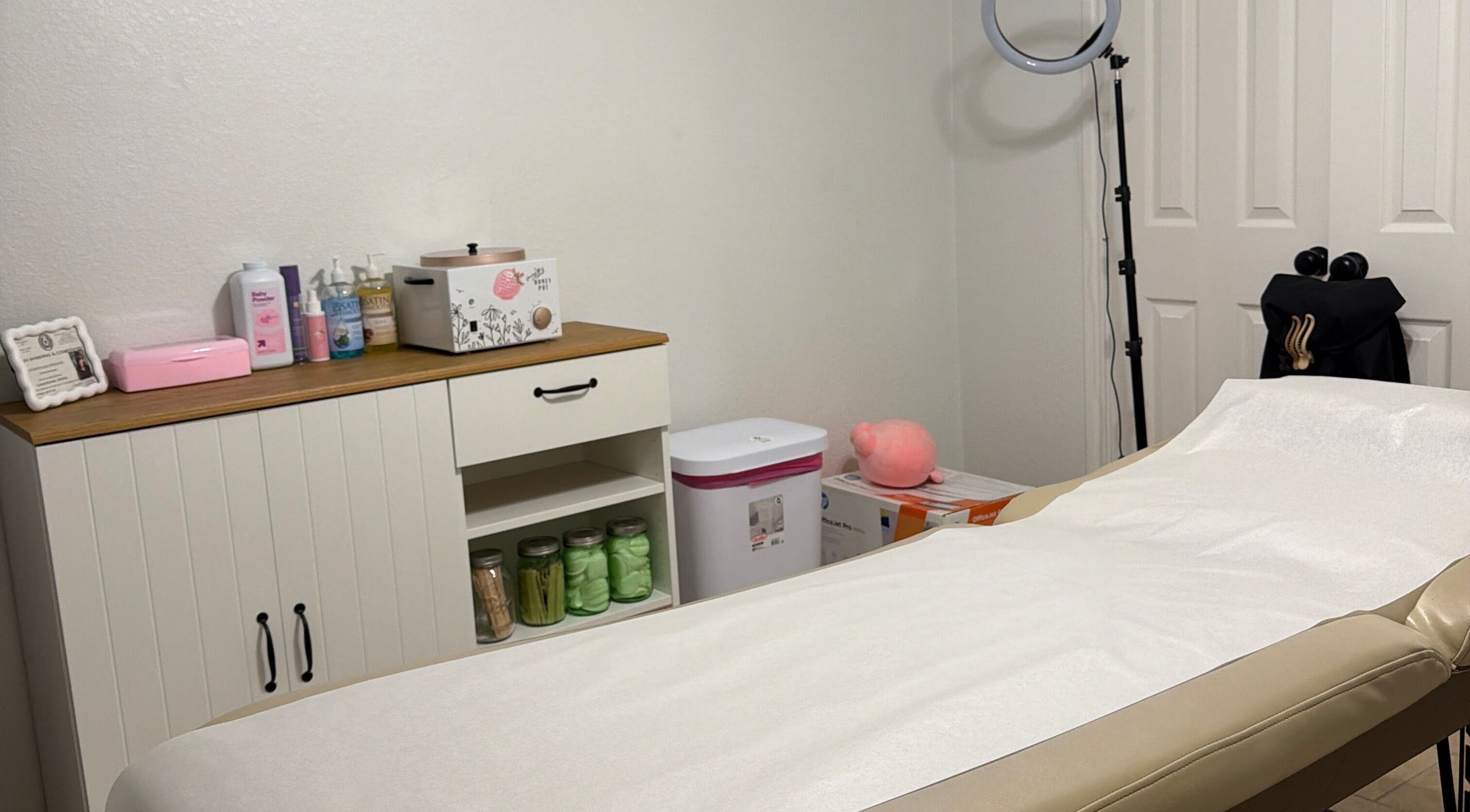 Cozy waxing room at Berry Smooth Waxing Co., Dickinson, Texas, US with a treatment bed and beauty products.