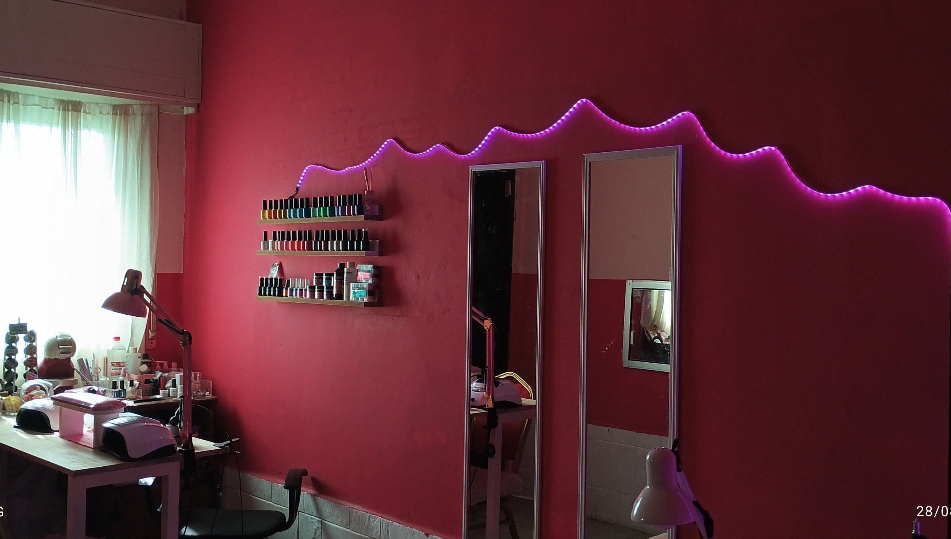 Interior moderno de Studio ML en Montevideo con esmaltes y luces LED rosas.