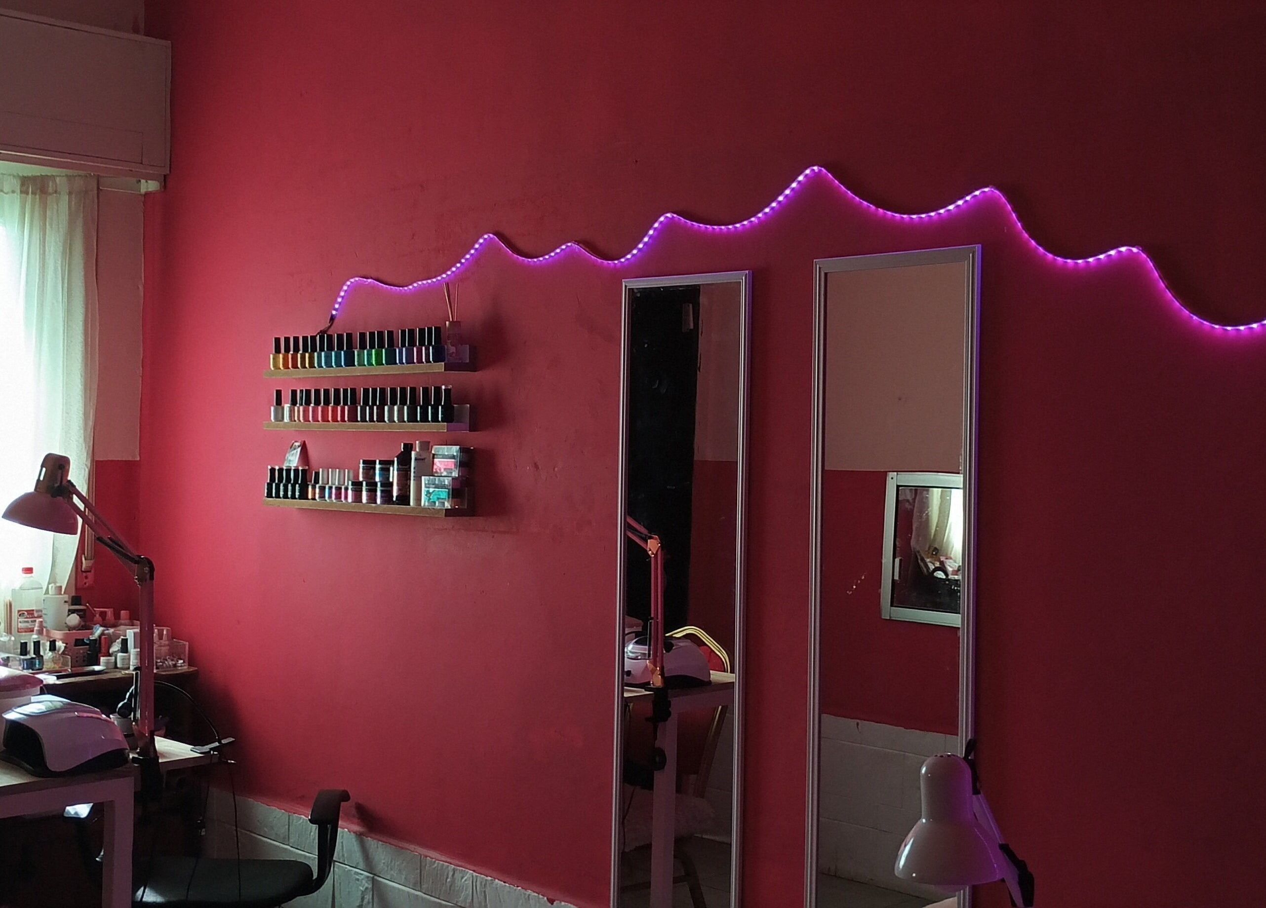 Interior moderno de Studio ML en Montevideo con esmaltes y luces LED rosas.