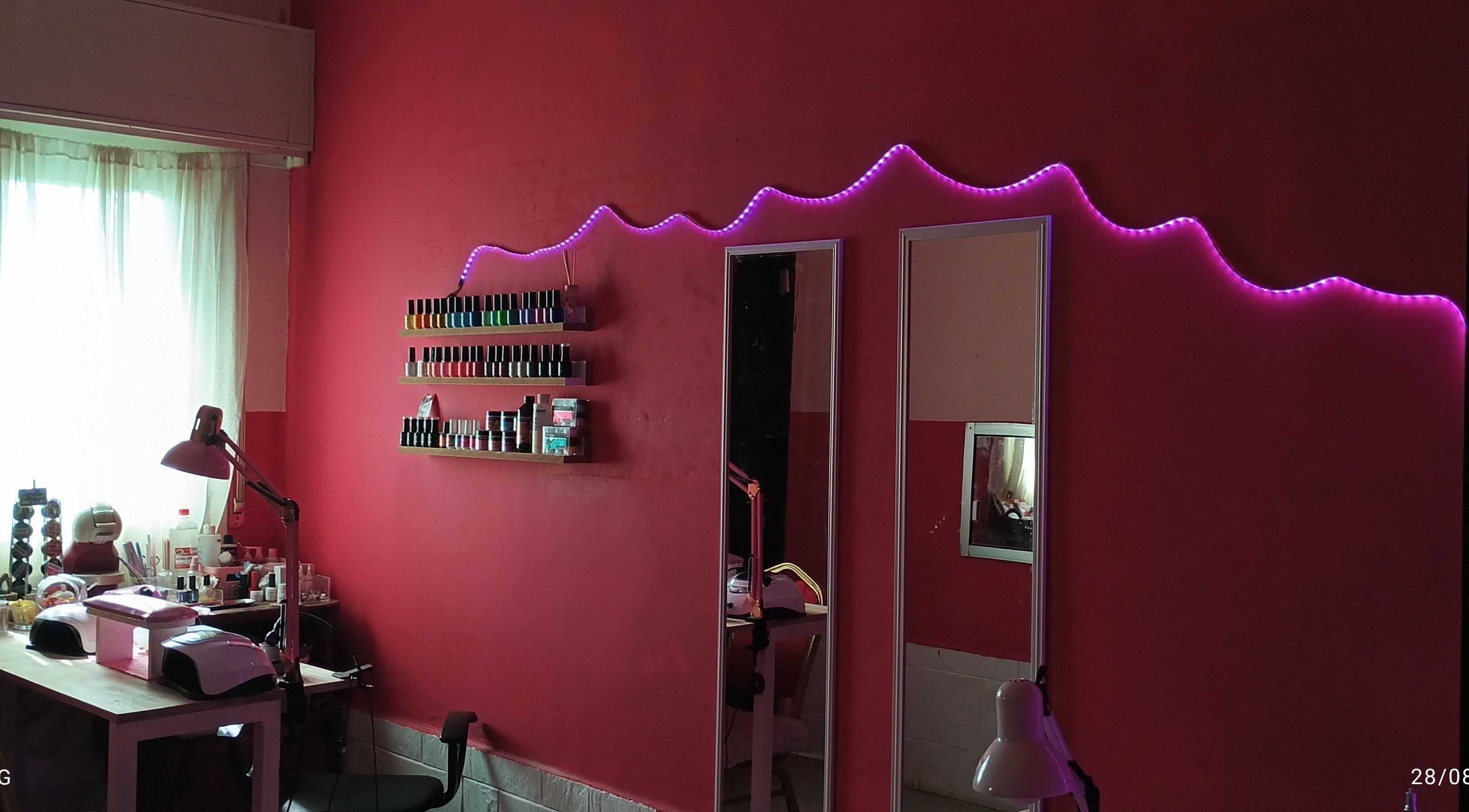 Interior moderno de Studio ML en Montevideo con esmaltes y luces LED rosas.