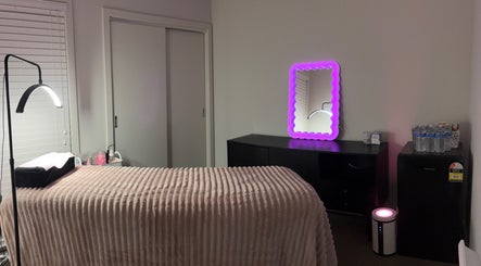 Calm treatment room at Blossom Beauty Bar, Melbourne, Victoria, AU with soft bed and illuminated mirror.