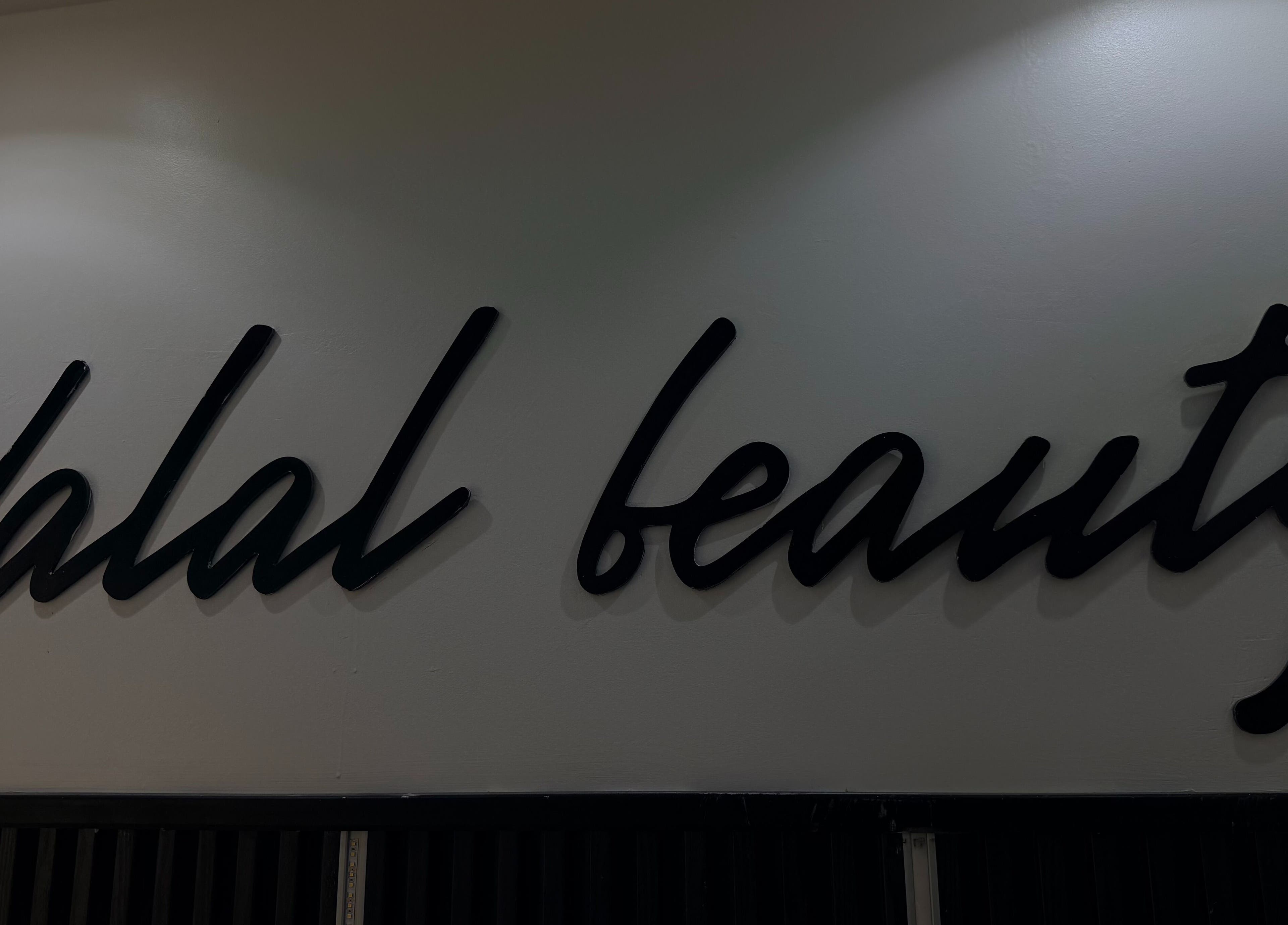 Enseigne élégante de DALAL | The Beauty Studio à Dakar, Région De Dakar, SN, en lettres cursives noires.