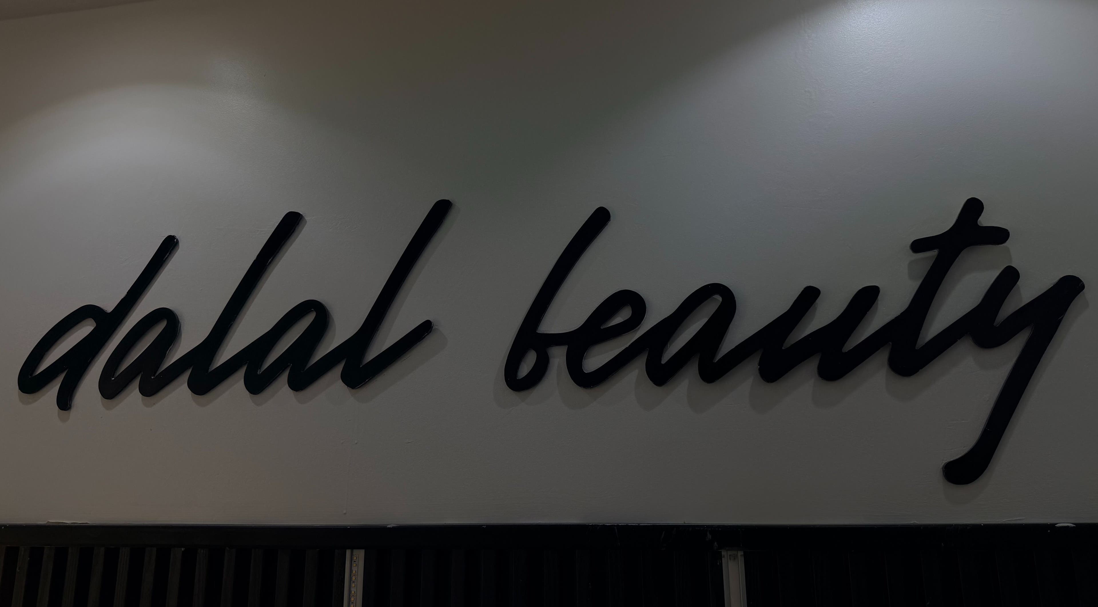 Enseigne élégante de DALAL | The Beauty Studio à Dakar, Région De Dakar, SN, en lettres cursives noires.
