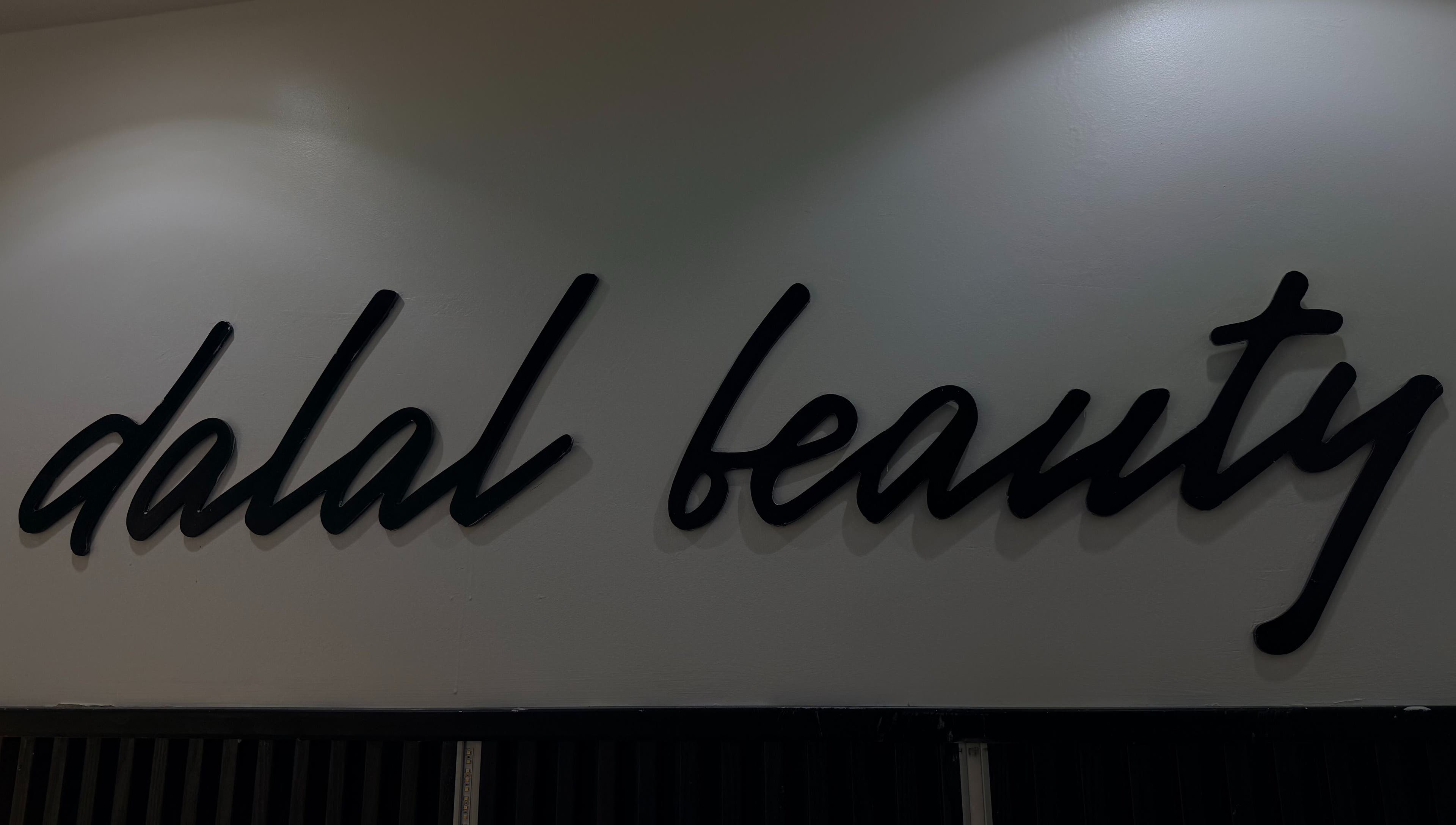 Logo élégant de DALAL | The Beauty Studio à Dakar, Région De Dakar, SN sur un mur blanc.