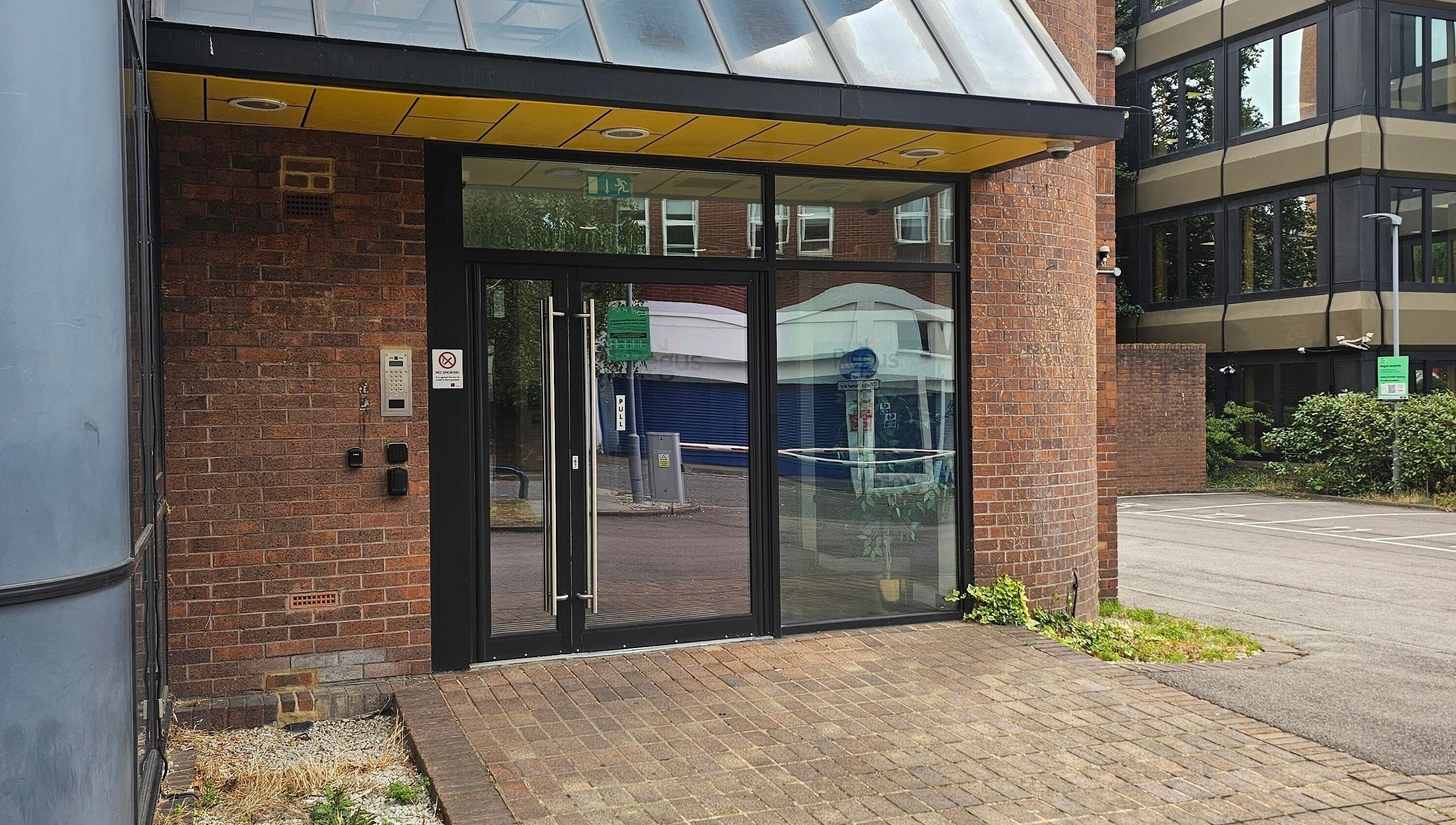 Front entrance of Nail Room in Bromley, England, GB with glass doors and brick exterior.