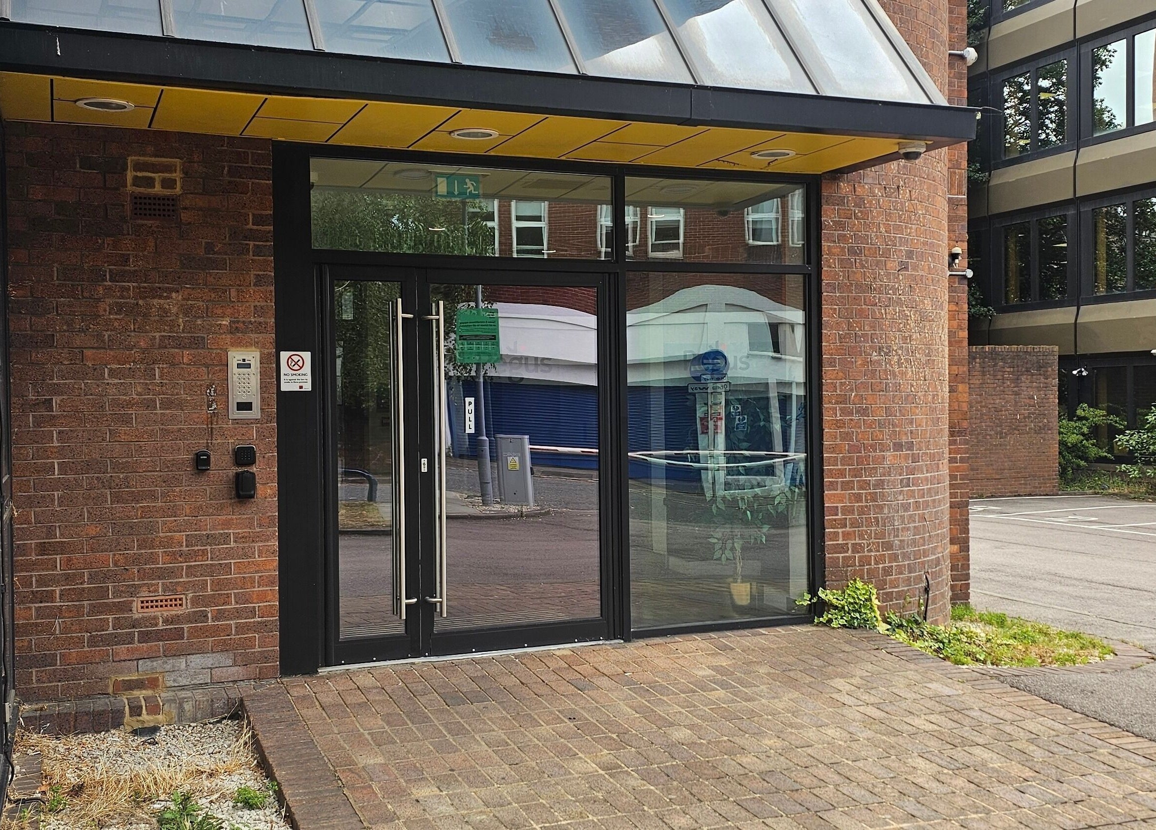 Front entrance of Nail Room in Bromley, England, GB with glass doors and brick exterior.