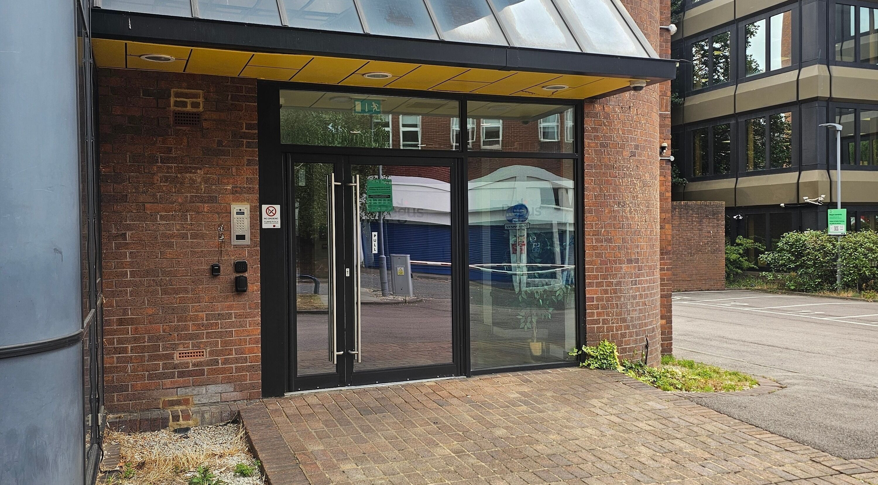 Front entrance of Nail Room in Bromley, England, GB with glass doors and brick exterior.