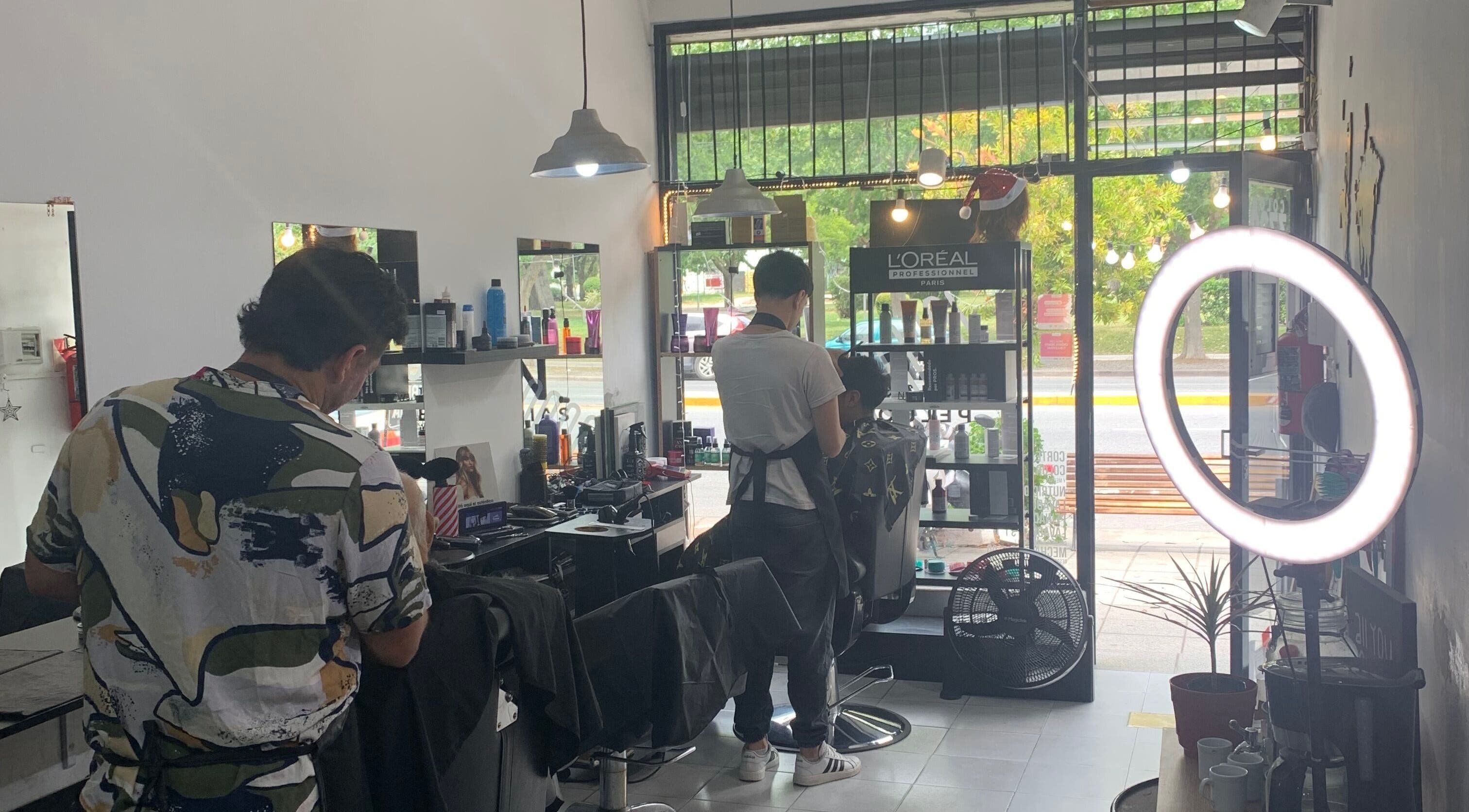 Interior moderno de ESAN Peluquerias, Mar del Plata, con estilistas trabajando junto a un ventanal iluminado.