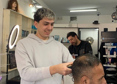 Estilista corta el cabello alegremente en ESAN Peluquerias, Mar del Plata, Provincia de Buenos Aires, AR.