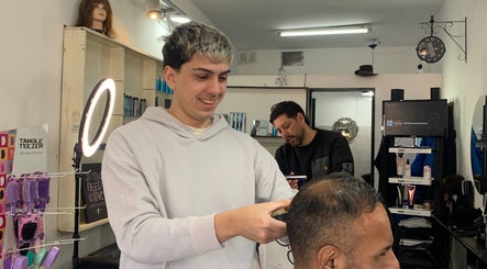 Estilista corta el cabello alegremente en ESAN Peluquerias, Mar del Plata, Provincia de Buenos Aires, AR.