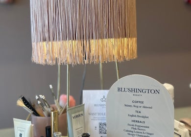Chic lamp and menu at Blushington Beauty, Poole, England, GB showcasing elegant decor and offerings.