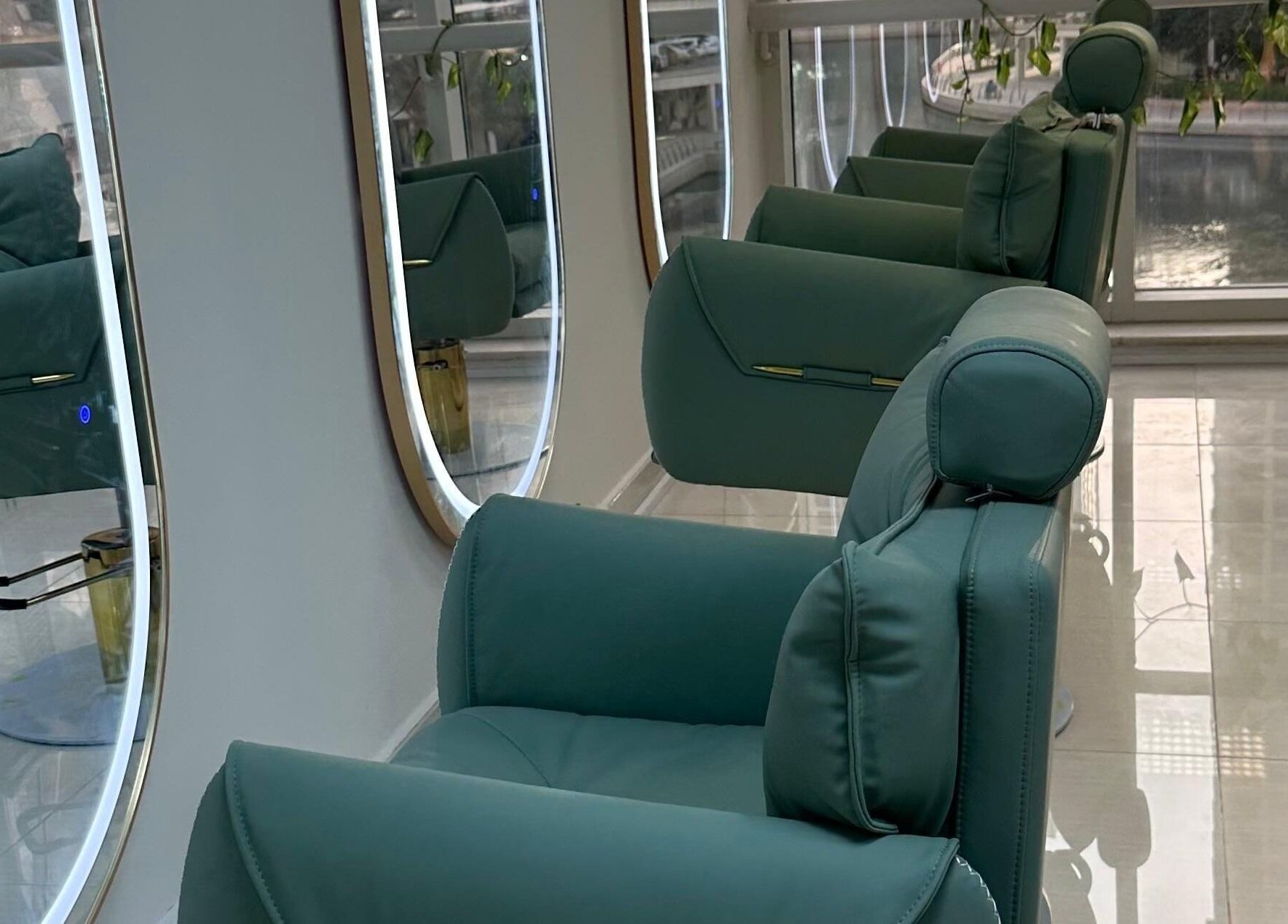 Elegant green salon chairs lined up at Jazz Loc Studio, 2nd Floor - #210, Dubai, AE, reflecting in round mirrors.
