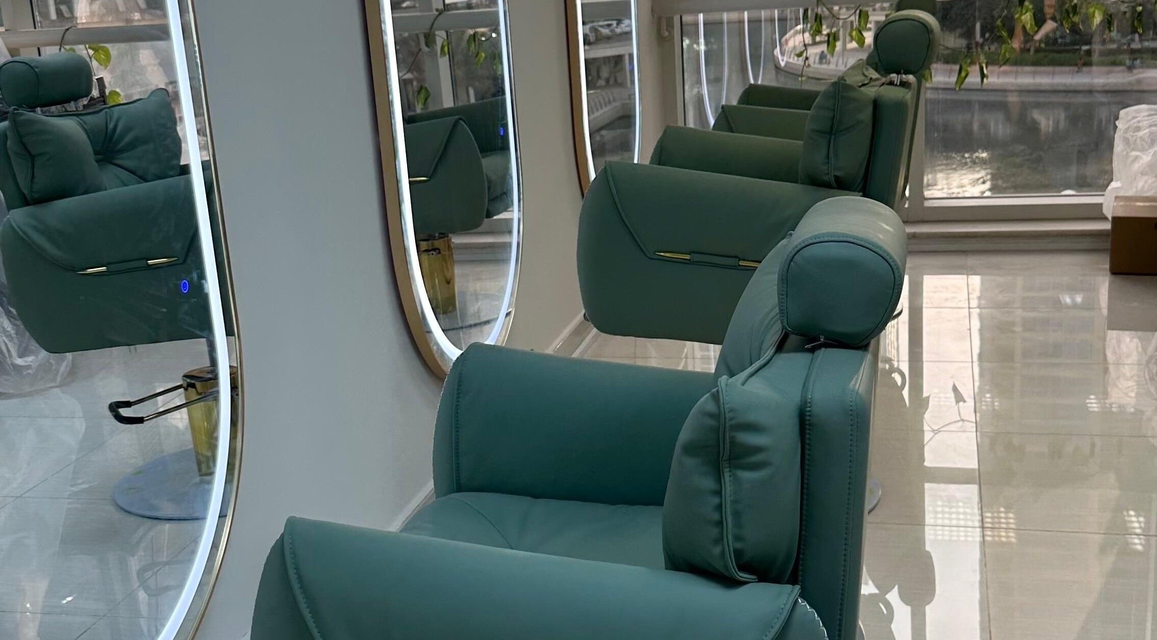 Elegant green salon chairs lined up at Jazz Loc Studio, 2nd Floor - #210, Dubai, AE, reflecting in round mirrors.