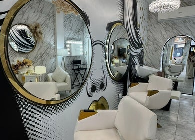 Elegant interior of HairByD, Glasgow, Scotland, GB showcasing stylish mirrors and plush seating.