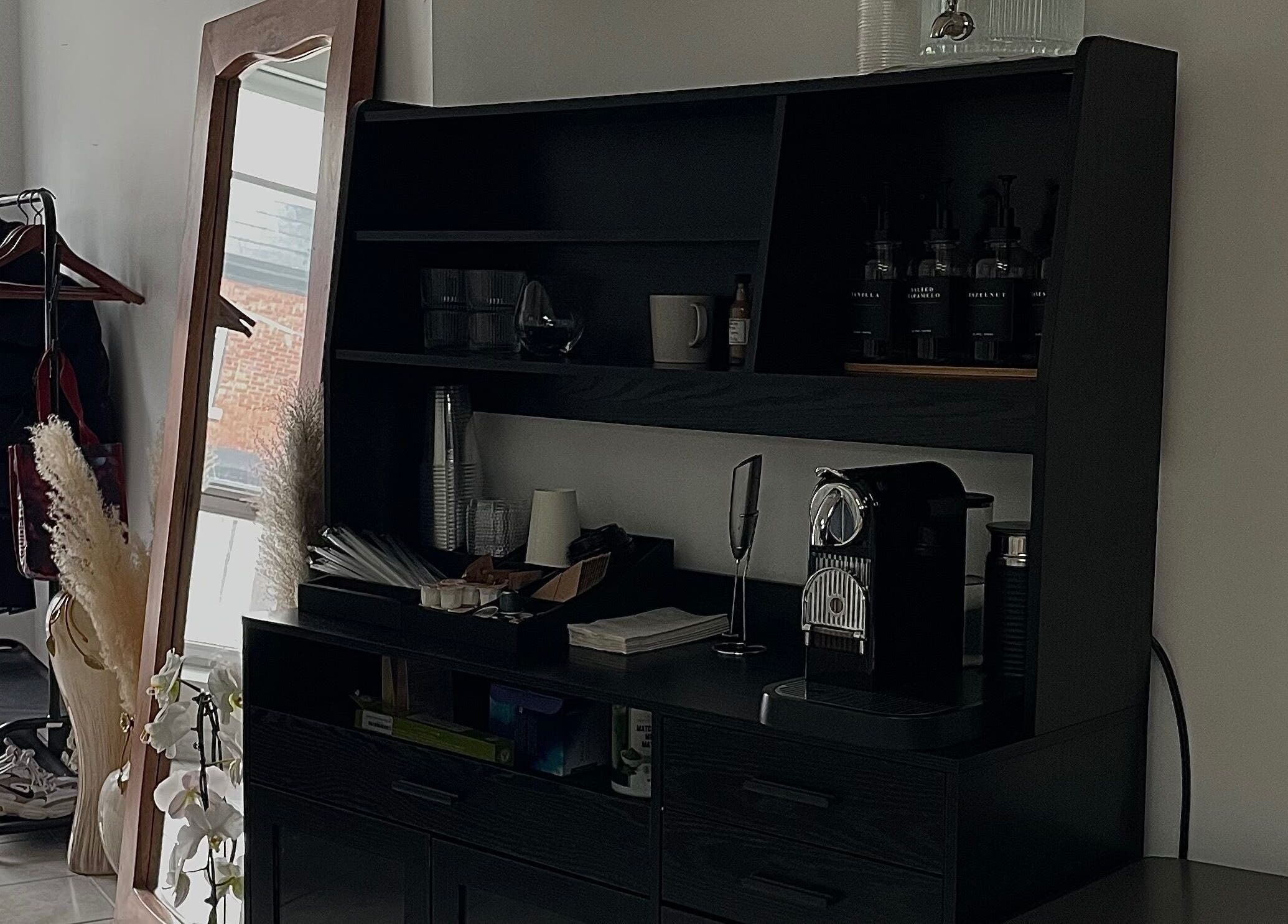 Sophisticated refreshment area at The Wink Room, Gatineau, Québec, CA with sleek shelving and coffee station.