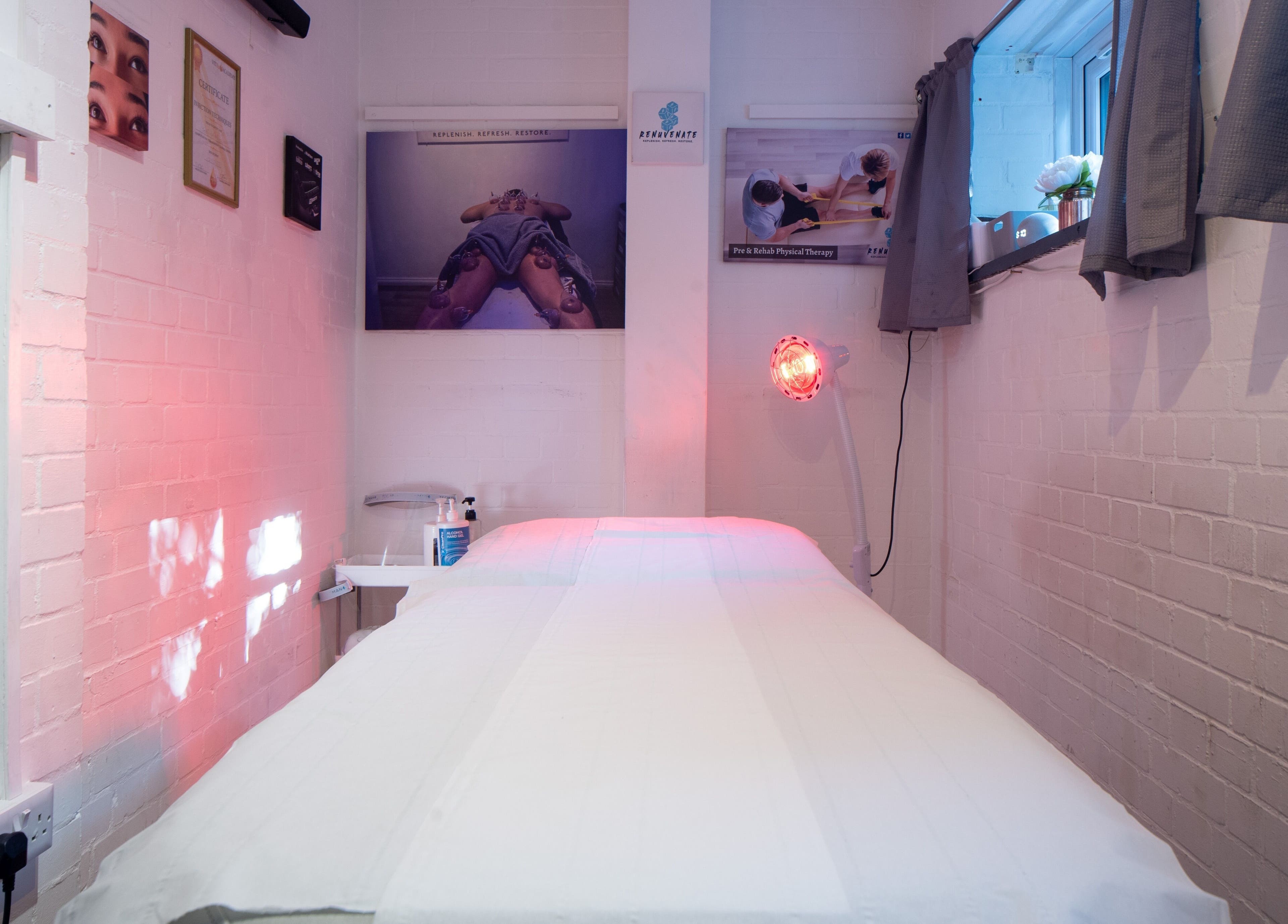 Cozy therapy room at Renuvenate Welling, England, GB with warm lighting and a massage table.
