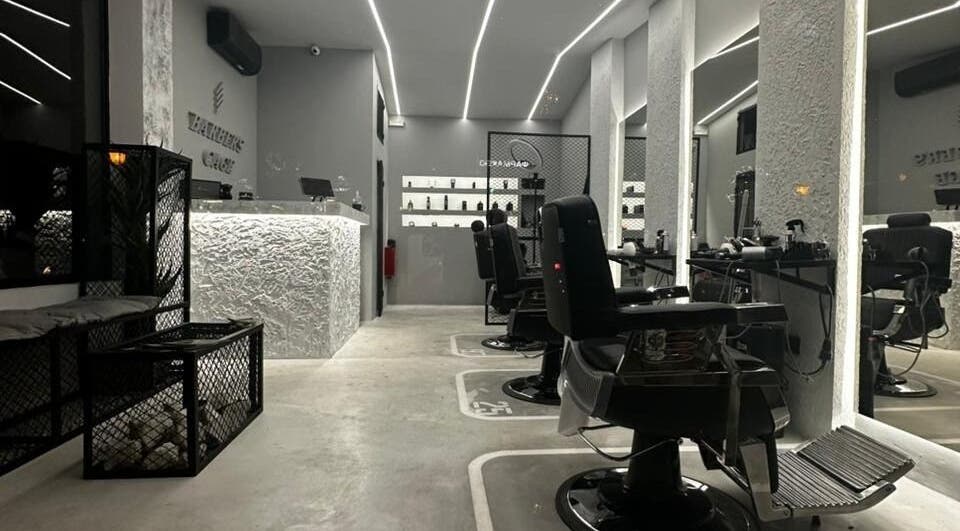 Κομψό εσωτερικό του Barber's Cage στην Evosmos, GR με μοντέρνα καθίσματα και φωτισμό.