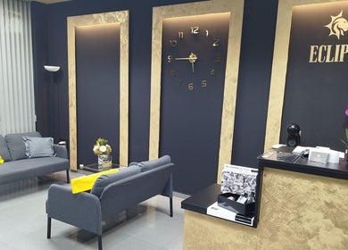 Acogedora sala de espera en Eclipse Boutique de Bienestar, Málaga, Andalucía, ES, con sofá gris y decoración elegante.