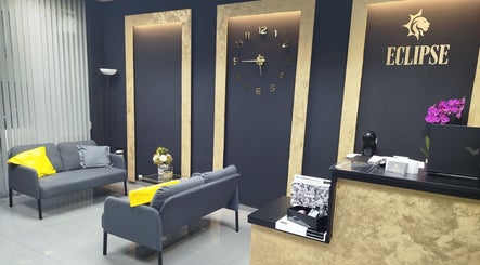 Acogedora sala de espera en Eclipse Boutique de Bienestar, Málaga, Andalucía, ES, con sofá gris y decoración elegante.