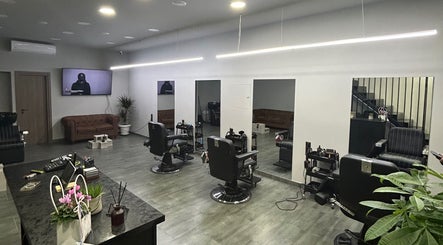 Εσωτερικό του HYBRIDBARBERSTUDIO, Θεσσαλονίκη, Ελλάδα με μοντέρνα καθίσματα και κομψή διακόσμηση.