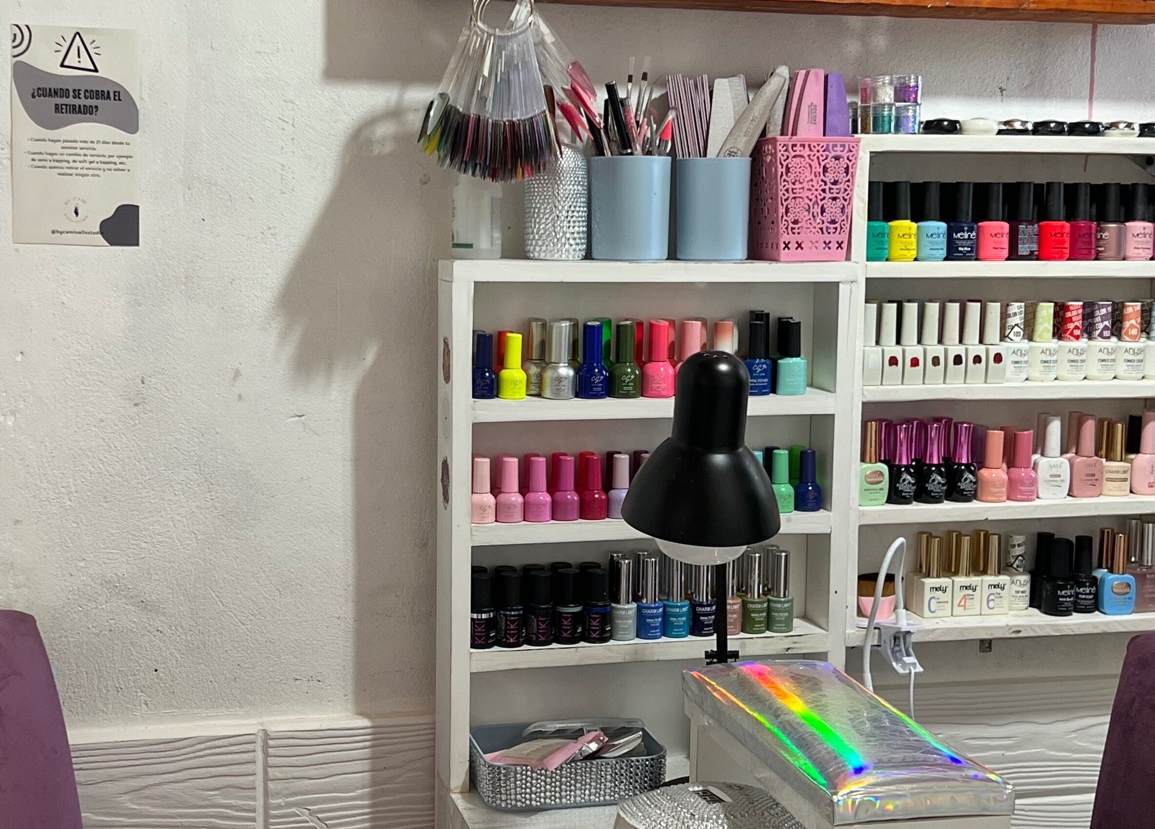 Interior de By Cami Nails Studio en General Pacheco, Provincia De Buenos Aires, AR con estantes de esmaltes de uñas.