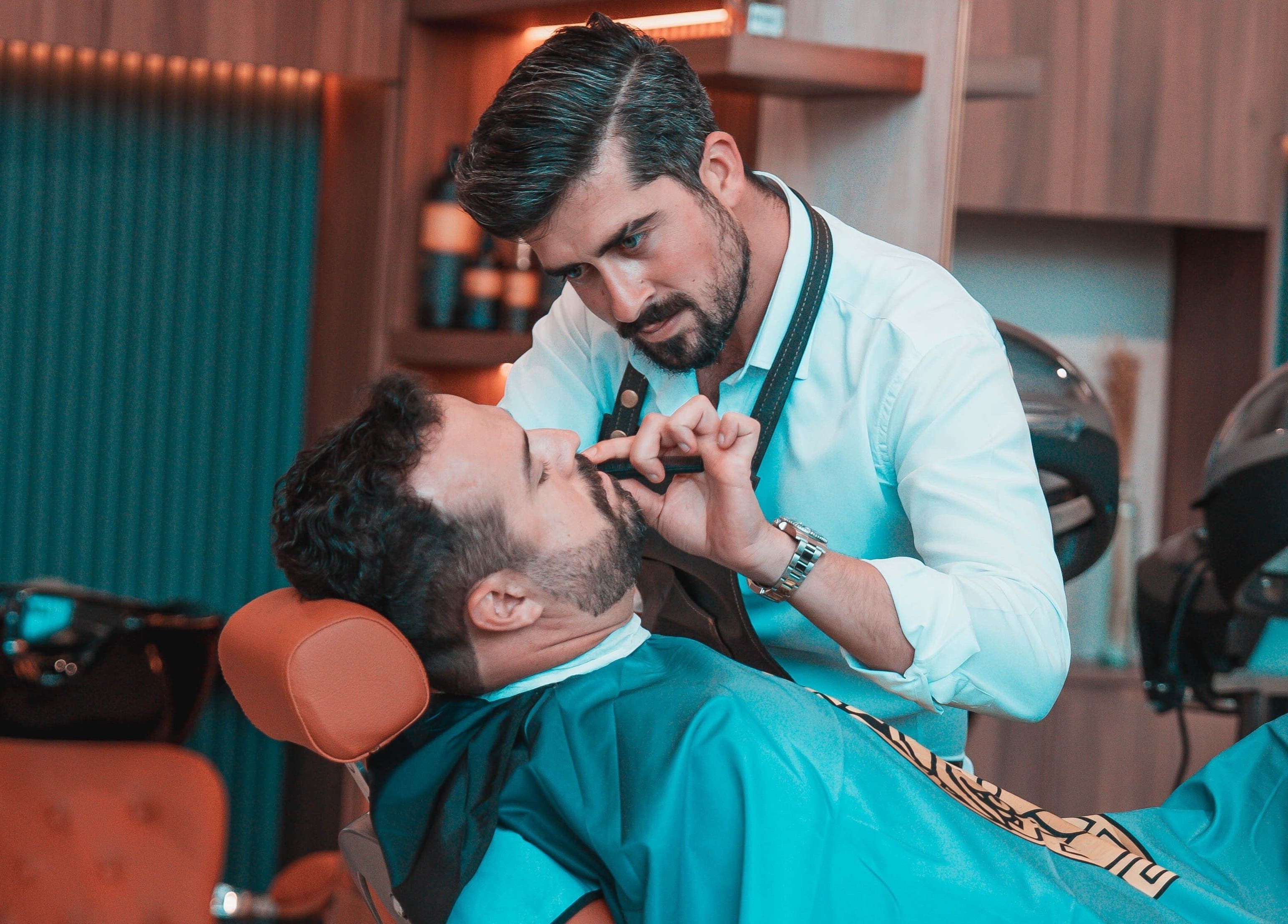 A barber attentively trims a client's beard at Bebek Gents Salon L.L.C, located in Dubai, AE.