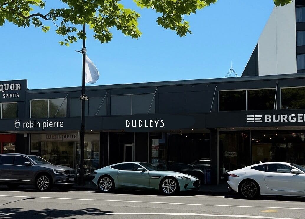 Dudleys storefront with parked cars on a sunny day in Auckland, Auckland, NZ.