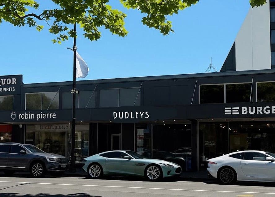 Street view of Dudleys, a wellness venue in Auckland, NZ, with modern aesthetics and parked cars.