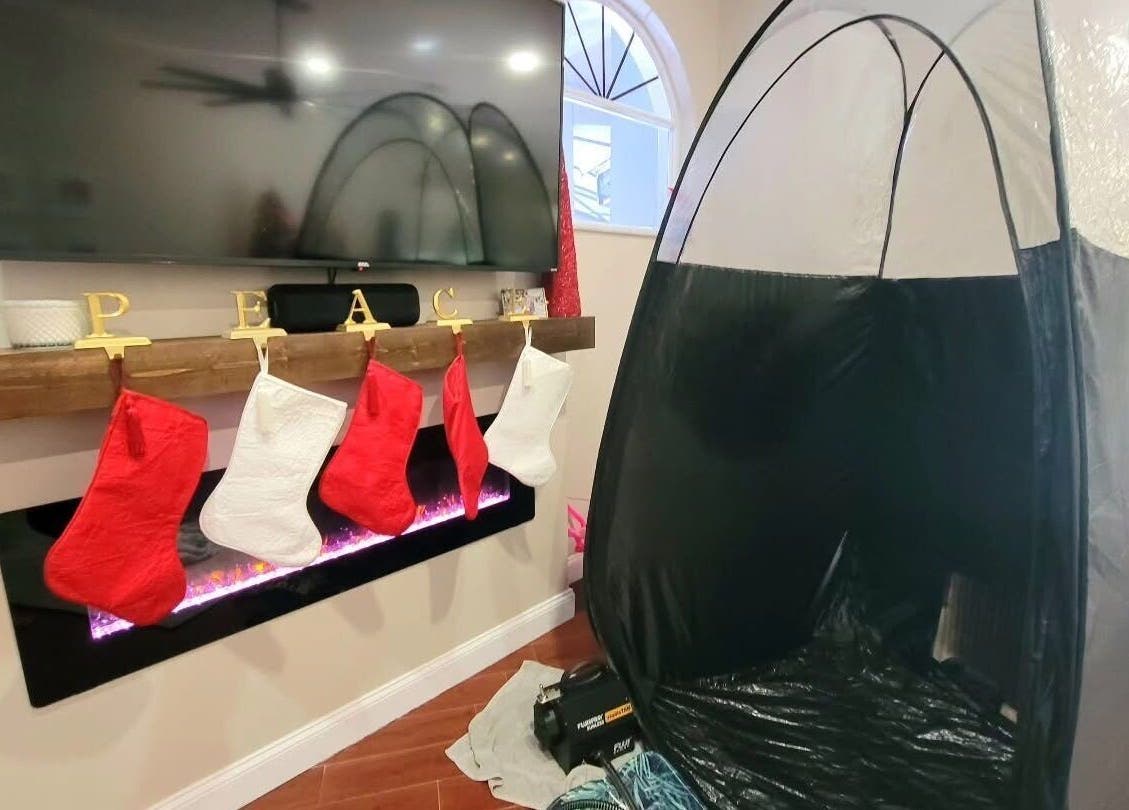 Modern tanning tent at Glow on the Go, Paisley, Scotland, GB, beside a cozy fireplace with stockings.