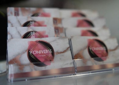 Business cards displayed at Yoniverse Curaçao, Willemstad, CW, featuring elegant design and branding.
