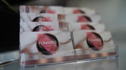 Business cards displayed at Yoniverse Curaçao, Willemstad, CW, featuring elegant design and branding.