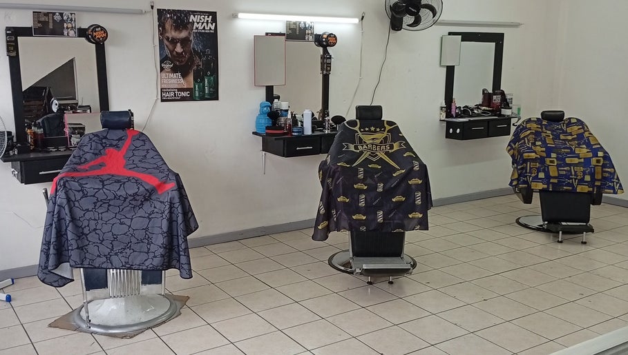 Interior moderno de The Upper Cut Barbershop en Heredia, Heredia, CR con sillas estilizadas.