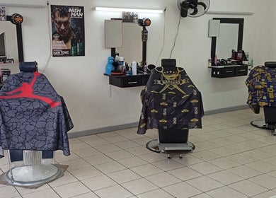 Interior moderno de The Upper Cut Barbershop en Heredia, Heredia, CR con sillas estilizadas.