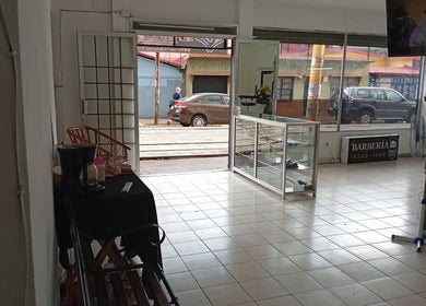 Interior luminoso de The Upper Cut Barbershop en Heredia, Heredia, CR, mostrando la entrada y sala de espera.