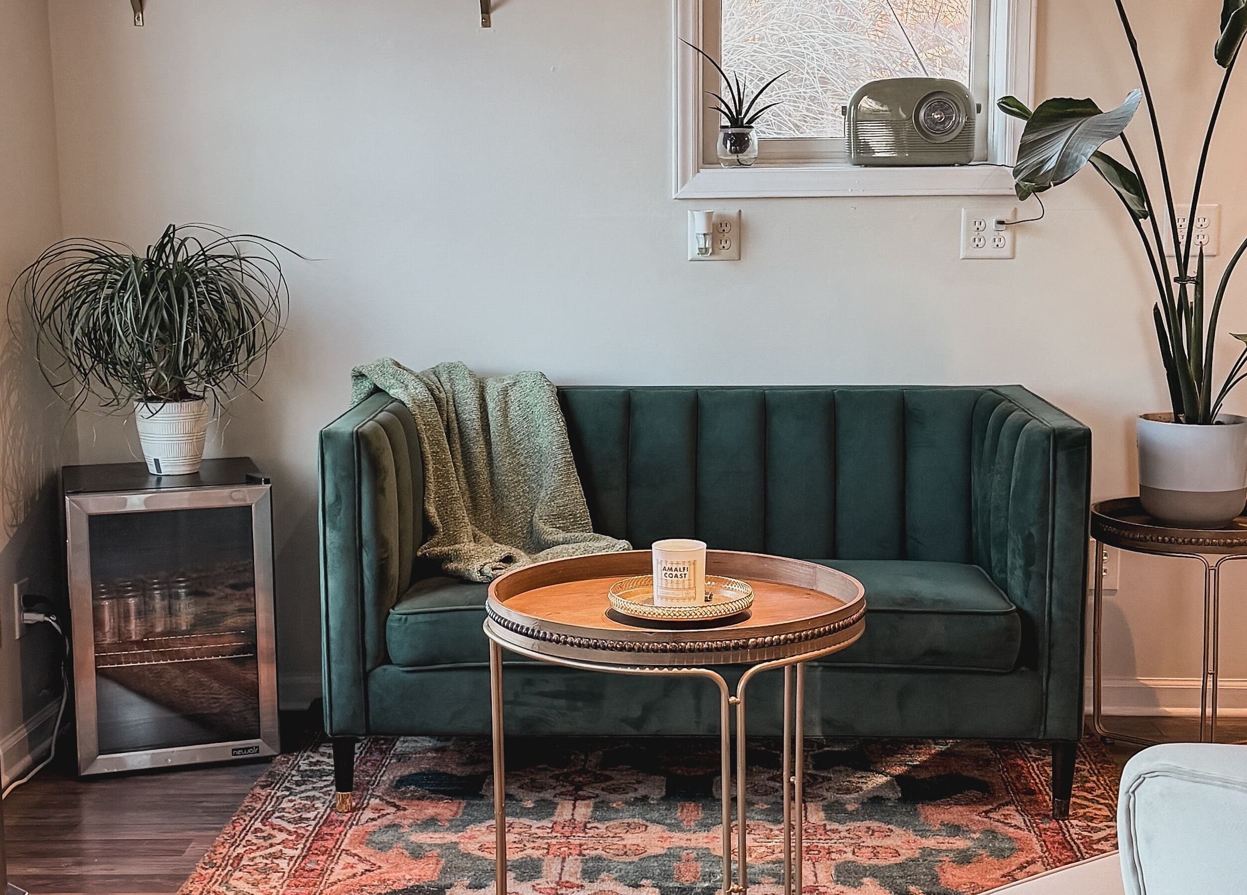 A stylish lounge area with a green velvet sofa at Brushes and Braids, Asheville, North Carolina, US.