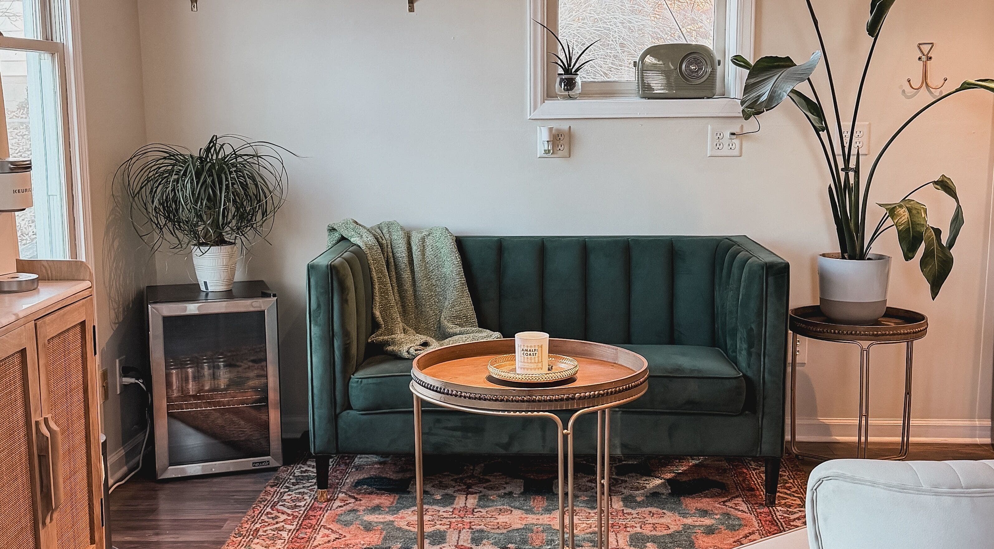 A stylish lounge area with a green velvet sofa at Brushes and Braids, Asheville, North Carolina, US.