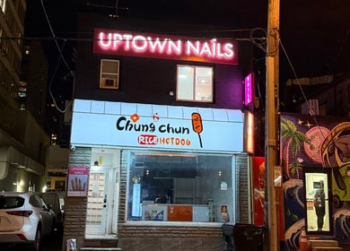 Bảng hiệu Uptown Nails and Beauty Spa nổi bật tại Toronto, Ontario, CA, vào ban đêm với ánh đèn neon sáng.