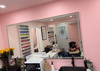 Không gian tiệm Uptown Nails and Beauty Spa với tường hồng nhạt và kệ sơn móng, Toronto, Ontario, CA.