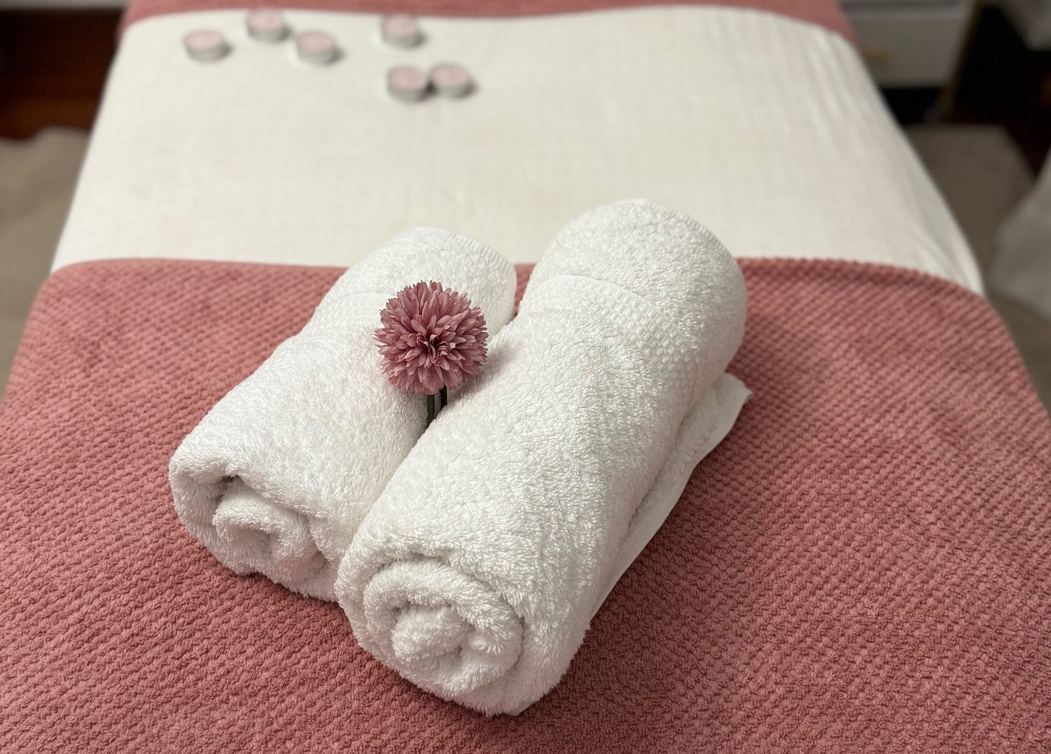 Toallas enrolladas y flor en Adri Oliver Masajes Bienestar, Donostia / San Sebastián, Euskadi, ES.