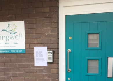 Front entrance of Beingwell in Dundee, Scotland, GB with a turquoise door and venue sign.