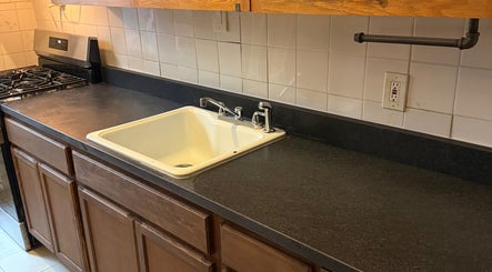 Modern kitchen sink and counter at CLEWIS IN CONSTRUCTION LLC, Queen, US.