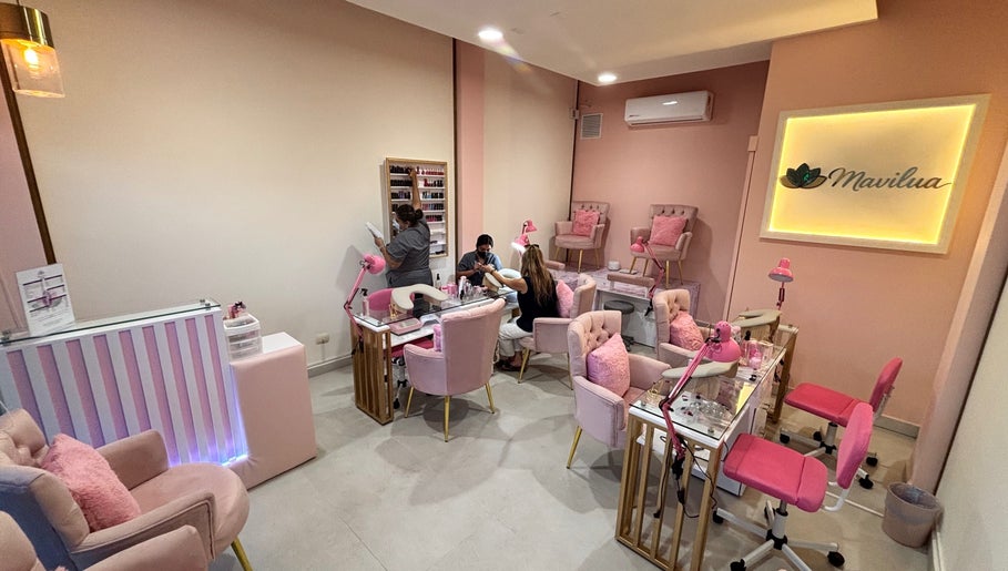 Chic interior of MAVILUA NAILS in Monterrey, Nuevo León, MX with pink decor and plush seating.
