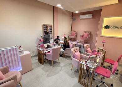 Chic interior of MAVILUA NAILS in Monterrey, Nuevo León, MX with pink decor and plush seating.