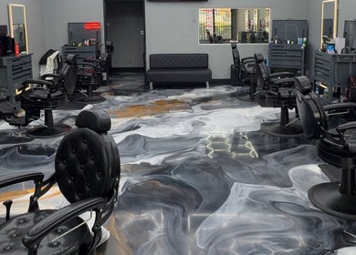 Sleek interior of The Spot barbershop in Los Angeles, California, US with modern black chairs and swirling floor design.